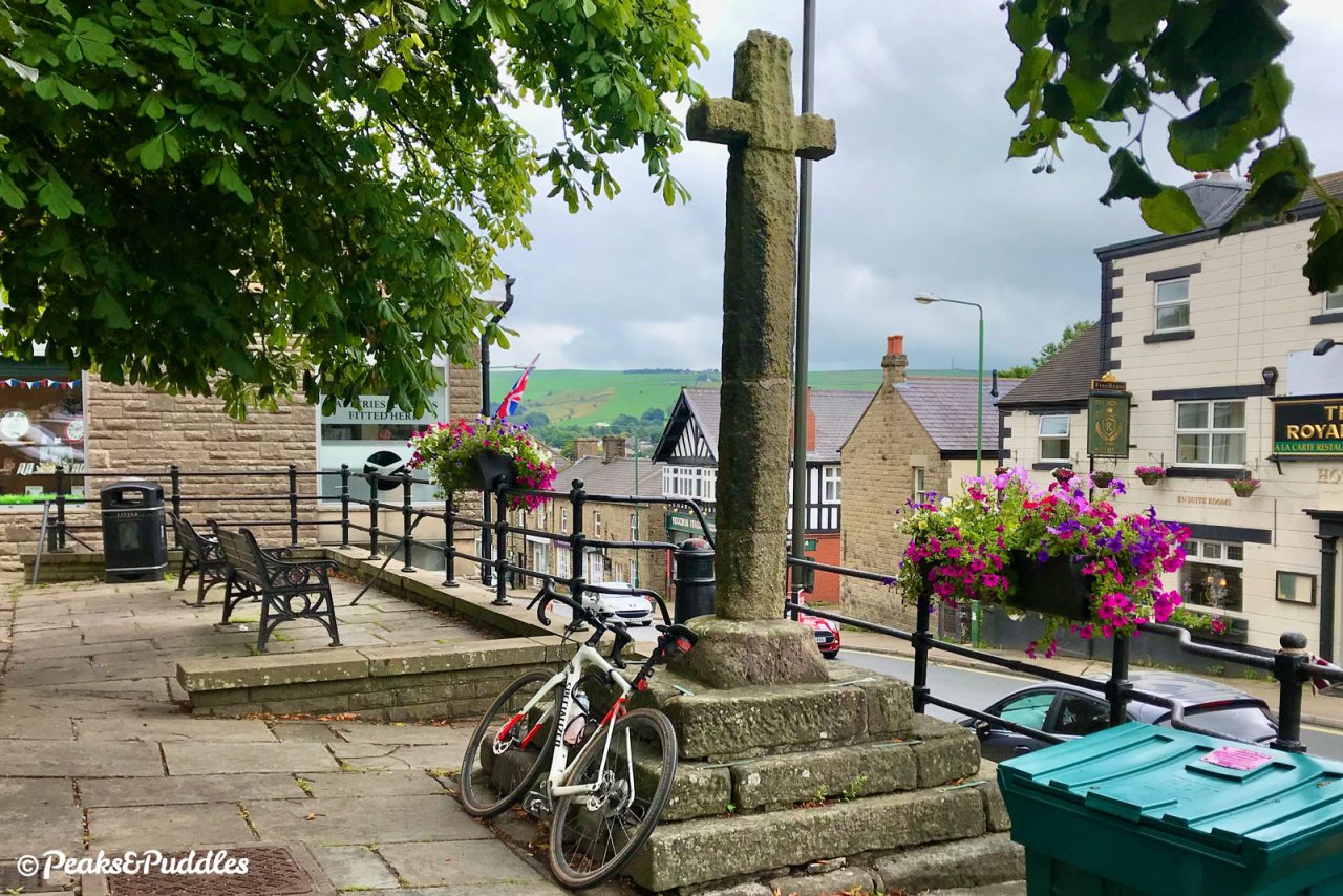 A bike propped up against the historic cross in the market place of Chapel-en-le-Frith