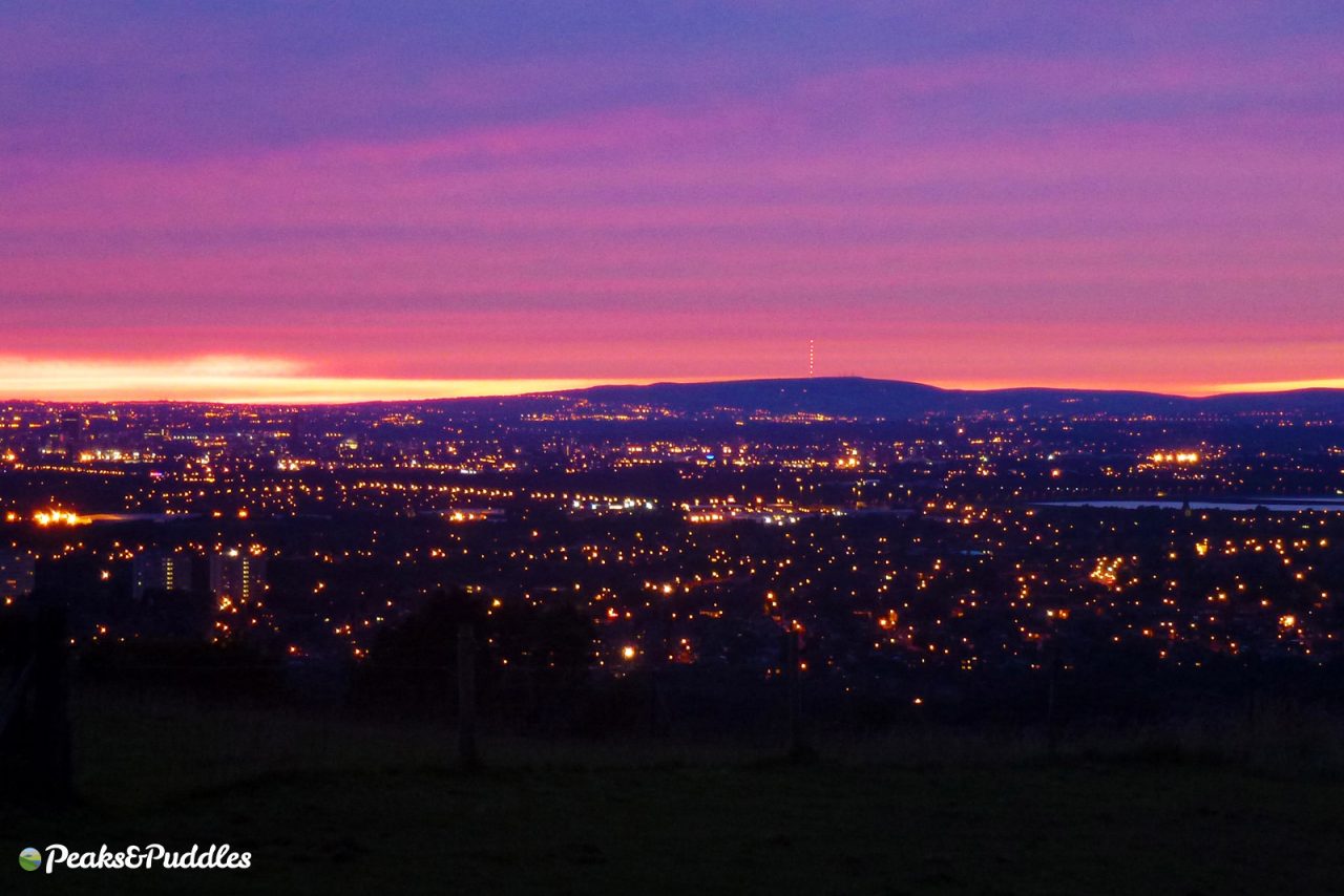 View across Greater Manchester to Winter Hill from Werneth Low at sunset with a red sky