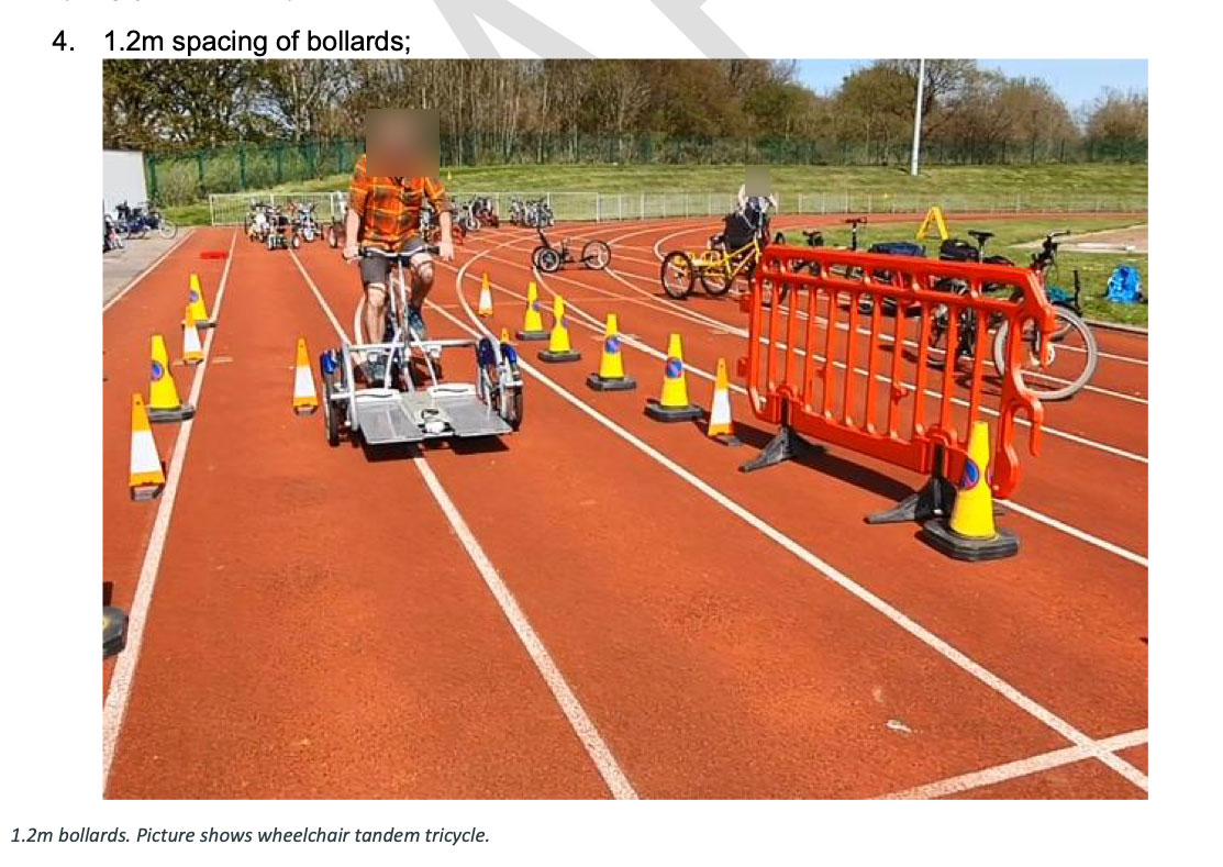 A council officer trials a 1.2 metre wide cycle through cones spaced at 1.2 metre distance on a running track, leaving almost zero excess clearance either side.